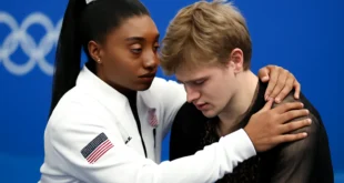 Imagem horizontal mostrando Simone Biles oferece apoio ao patinador Ilia Malinin na Olimpíada de Inverno